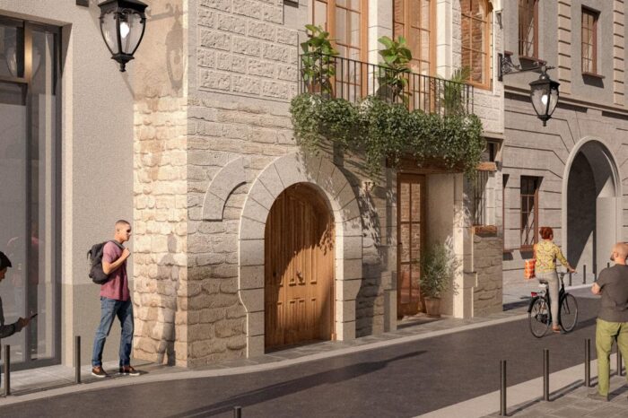 Restored historic façade with stone arch entrance and balcony in Avinyó 17, Barcelona