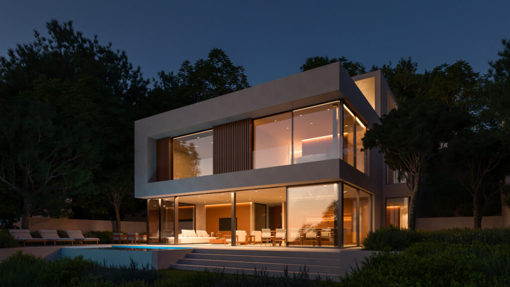 Luxury modern villa in Begur illuminated at night, featuring floor-to-ceiling glass windows and warm ambient lighting.